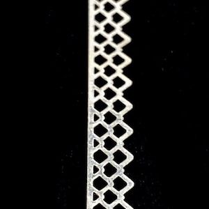 May include: A white decorative trim with a repeating diamond pattern. The trim is made of a thin, flexible material and has a scalloped edge.
