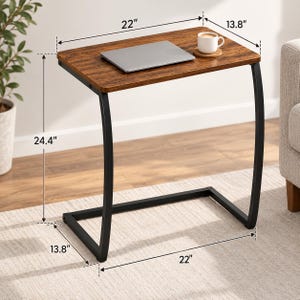 May include: A C-shaped side table with a dark brown wood-grain top and a black metal frame. Dimensions are 22 inches wide, 13.8 inches deep, and 24.4 inches high. A laptop and a white mug on a coaster are placed on the tabletop surface.