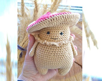 May include: A crocheted mushroom amigurumi toy with a red and white hat and a smiling face.