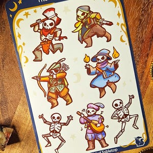 May include: A sticker sheet featuring cartoon skeletons in various fantasy roles. The skeletons are depicted as a warrior with an axe, a rogue with a dagger, an archer with a bow, a wizard with flames, a bard with a lute, and a dancing skeleton.
