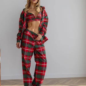 Può includere: Un completo pigiama a quadri rossi, verdi e bianchi. Il set comprende una camicia abbottonata a maniche lunghe, un reggiseno e pantaloni a gamba larga. L'outfit è realizzato in un tessuto morbido e confortevole.