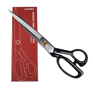 May include: Heavy-duty fabric scissors with a 12-inch blade, featuring black handles and a silver blade. The scissors are displayed next to a red box with the text "KEARING FABRIC SCISSORS". The box also indicates the scissors are 12 inches.