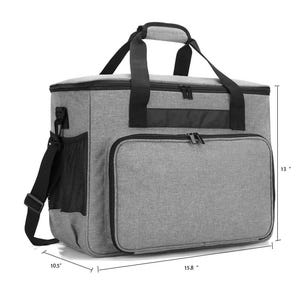 May include: A gray insulated cooler bag with black accents. The bag has a top handle, a shoulder strap, and a front zippered pocket. It measures 15.8 inches wide, 13 inches high, and 10.5 inches deep.