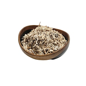 May include: A wooden bowl filled with chopped, light-colored, dried herbs. The bowl is oval-shaped and has a dark rim. The herbs appear to be small pieces of roots and stems, with a natural, earthy appearance.