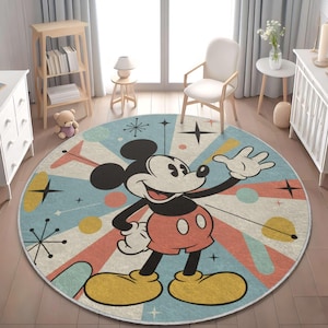 Op de afbeelding: Een rond vloerkleed met een klassieke Mickey Mouse-illustratie in het midden. Het ontwerp bevat een retro-geïnspireerde achtergrond met lichtblauwe, koraalkleurige en crèmekleurige zonnestralen, geaccentueerd door gele cirkels en zwarte sterren.