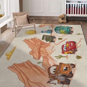 May include: A rectangular area rug featuring a desert landscape with illustrations of cartoon vehicles, including a red race car, a rusty orange tow truck, a green van, and a green military vehicle, set against tan rock formations and cacti.