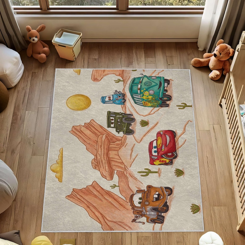 Puede incluir: Una alfombra rectangular que presenta un paisaje des&eacute;rtico con formaciones rocosas rojas, cactus y un sol amarillo. El dise&ntilde;o incluye personajes de dibujos animados que se asemejan a veh&iacute;culos, como un coche de carreras rojo y un cami&oacute;n.