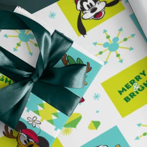 May include: A gift wrapped in white paper featuring a repeating pattern of Goofy, Pluto, and starburst shapes in lime green and turquoise, tied with a dark green satin ribbon. The paper includes the text MERRY & BRIGHT in lime green letters.