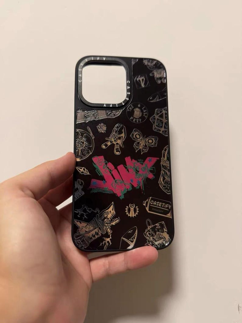 Peut inclure: Coque de t&eacute;l&eacute;phone noire avec un imprim&eacute; graphique color&eacute; repr&eacute;sentant un loup, un requin, un papillon et le texte "CASETIFY".