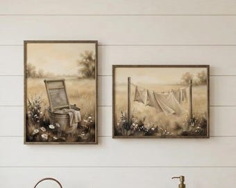 May include: Two framed wall art prints featuring sepia-toned illustrations of a vintage washboard in a metal basin and laundry hanging on a clothesline in a field, displayed above a wooden shelf with a copper watering can and a folded towel.