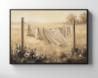 May include: A framed wall art print depicting a sepia-toned landscape with laundry hanging on a clothesline between two wooden posts. The scene features light-colored fabric sheets blowing in the wind, set against a field of tall grass and flowers.