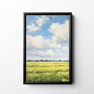 May include: A framed wall art print featuring a landscape painting of a vibrant yellow and green grassy field under a bright blue sky filled with fluffy white clouds. The artwork is enclosed in a simple black rectangular frame with a thin border.