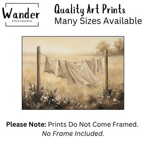 May include: An art print featuring a sepia-toned landscape with laundry hanging on a clothesline between two wooden posts. The text reads: Wander Printworks, Quality Art Prints, Many Sizes Available, Please Note: Prints Do Not Come Framed. No Frame Included.