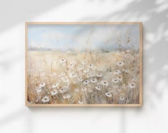 May include: A framed landscape painting featuring a field of white daisies and tall grasses in shades of beige and gold. The sky is a soft blue. The artwork is in a light wood frame.