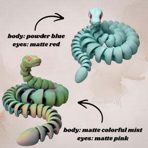 May include: Two articulated snake toys. One is powder blue with matte red eyes, the other is matte colorful mist with matte pink eyes. The image includes the text "body: powder blue eyes: matte red" and "body: matte colorful mist eyes: matte pink".