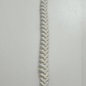 May include: A white, articulated spine model, showcasing the vertebrae and spinal structure. The model is made of a solid, opaque material and is positioned vertically against a white background.