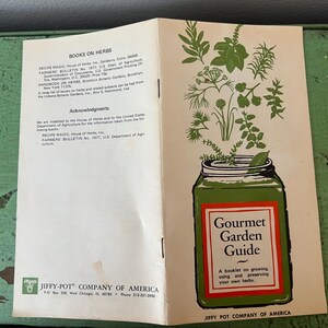 May include: Open vintage booklet titled "Gourmet Garden Guide" with a green jar illustration and herbs. The booklet is open, showing text about herbs and acknowledgments. The cover features the text "Gourmet Garden Guide".