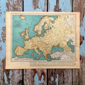 May include: A vintage map of Europe from the Rand McNally World Atlas and Gazetteer. The map features countries in shades of yellow, green, and brown, with blue oceans. The title "Europe" is printed at the top. The map is on a cream-colored paper.