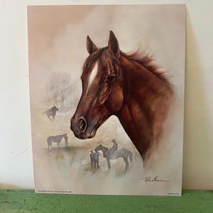 May include: A print featuring a detailed portrait of a brown horse's head with a white blaze. The artwork includes a soft, blurred background with additional horses and figures, creating a serene equestrian scene. Signed by Rene Maurice.