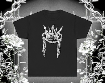 May include: A black short-sleeve t-shirt featuring a white graphic print of a crown with two long, feathered wings extending downward from the sides. The design is centered on the chest, showcasing a detailed, sketch-like illustration of the crown.