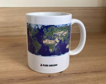 May include: A white ceramic mug featuring a pixelated world map graphic wrapped around the center. Below the map, the text FLEXI ARCADE is printed in black, accompanied by a small red icon of a person. The mug has a standard handle.