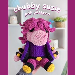 Puede incluir: Una muñeca de ganchillo llamada "Chubby Susie" con cara y pelo rosa, vestida con un atuendo morado con detalles en negro y amarillo. El texto "chubby susie pdf pattern" se muestra encima de la muñeca.