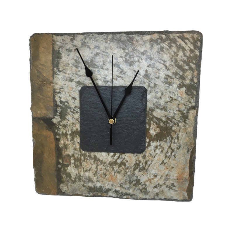 May include: Square slate clock with a black square clock face. The clock face has black hands and a gold-colored center. The slate has a natural, textured appearance with shades of gray, brown, and tan.