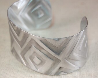 Brazalete de aluminio con diseño cuadrado y metal texturizado