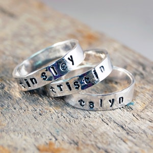 Puede incluir: Tres anillos de plata con los nombres "Tinsley", "Tristan" y "Taryn" grabados en ellos.