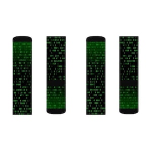 Puede incluir: Cuatro calcetines negros y verdes con un patr&oacute;n de c&oacute;digo binario verde.