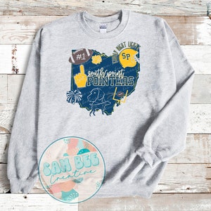 May include: Gray sweatshirt with a blue and yellow graphic of the state of Ohio. The graphic includes the text "South Point Pointers" and various sports-related icons, including a football, a cheerleader, and a dog.