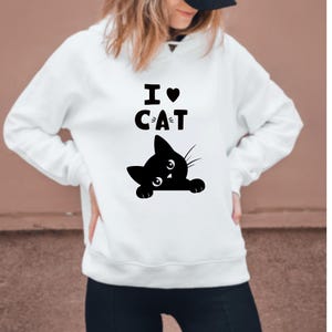 Pu&ograve; includere: Felpa con cappuccio bianca con un'immagine di un gatto nero e la scritta "I love cat" stampata sul davanti.