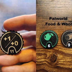 Pu&ograve; includere: Un set di gettoni da gioco circolari con bordi smerlati. Un gettone mostra +1/+0 e il numero 11. Un altro gettone presenta un'icona di mela verde e il numero 6. Un terzo gettone mostra un'icona di tronco di legno e il numero 9. Testo Palworld Food & Wood.