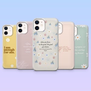Pode incluir: Cinco capas de telemóvel com citações inspiradoras e desenhos florais. As capas são em várias cores, incluindo amarelo, rosa e verde. Uma capa tem o texto "I am enough for me." Outra diz "You become what you believe."