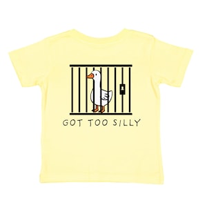 May include: A yellow short-sleeved t-shirt with a cartoon goose in a cage on the back. The text "GOT TOO SILLY" is printed below the image.