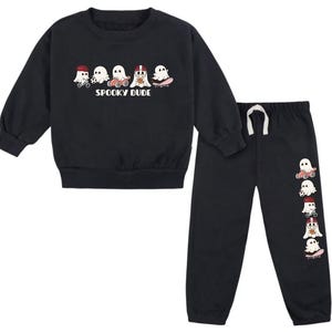 Könnte beinhalten: Schwarzes zweiteiliges Kinder-Outfit, bestehend aus einem Sweatshirt mit Rundhalsausschnitt und einer Jogginghose. Das Sweatshirt hat eine Grafik von Cartoon-Geistern mit dem Text "Spooky Dude". Die Jogginghose hat eine passende Geistergrafik.