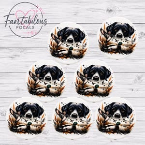 May include: Seven white ceramic focal pieces with a hunting theme. Each piece features a black and white dog, a duck, and foliage in shades of brown and green. The pieces are arranged on a white wooden surface.