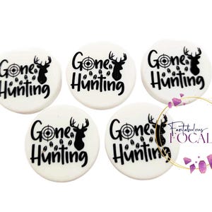 May include: Five white round ceramic coasters with black text and a deer silhouette. The text on the coasters reads "Gone Hunting" with a target symbol and deer footprints.
