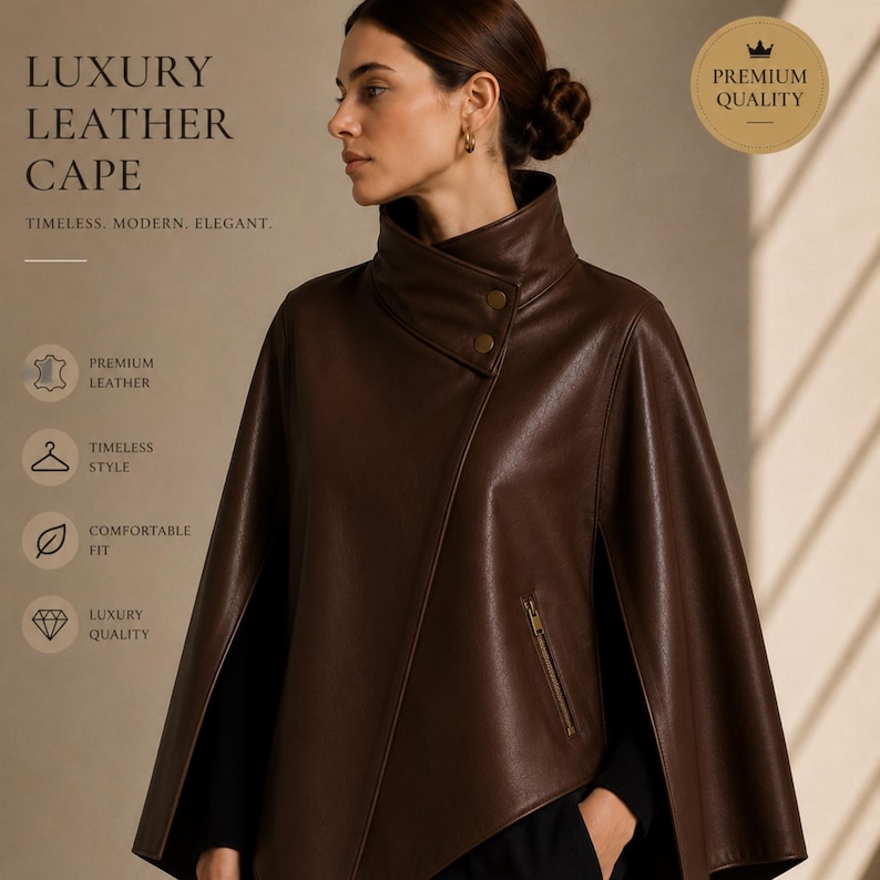 May include: A brown leather cape with a high collar and asymmetrical front. The cape features a zipper and button closure. Text on the image reads "LUXURY LEATHER CAPE" and "PREMIUM QUALITY". The cape is described as timeless, modern, and elegant.