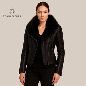 May include: A black leather jacket featuring a fur collar and a zip-up front. The jacket has a fitted design and is a classic outerwear item. The brand name "ZEONLEATHER" is displayed on the upper left.