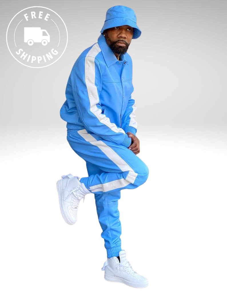 Puede incluir: Un ch&aacute;ndal azul claro con rayas blancas en los laterales. La chaqueta tiene cuello y los pantalones tienen cintura con cord&oacute;n. El conjunto se combina con un gorro de pescador a juego y zapatillas altas blancas. El conjunto es de estilo deportivo e informal.