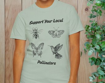 May include: A light green t-shirt with the text "Support Your Local Pollinators" printed in black. The shirt features illustrations of a bee, butterfly, hummingbird, and another butterfly.