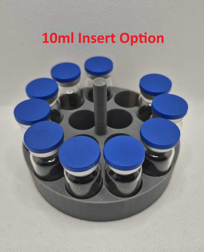 May include: A gray circular holder with ten clear glass vials, each sealed with a blue cap. The text "10ml Insert Option" is displayed in red at the top. The vials are arranged around a central gray post.