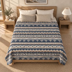 Puede incluir: Una cama con una manta estampada en azul, marrón y blanco con rayas horizontales de formas geométricas y puntos. La cama incluye dos almohadas blancas grandes y dos almohadas rectangulares beige más pequeñas sobre un marco de madera.