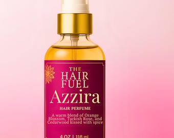 May include: A clear glass bottle of Azzira hair perfume with a gold cap and a pink label. The label reads "THE HAIR FUEL Azzira HAIR PERFUME" and lists the scent as a warm blend of Orange Blossom, Turkish Rose, and Cedarwood. The bottle contains 4 oz of product.