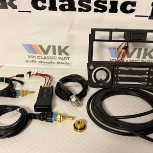 May include: A collection of car components, featuring black wiring, sensors, and a dashboard frame. The parts are displayed on a light surface, with the "VIK Classic Part" logo visible in the background.