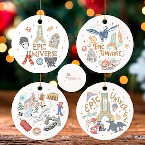 May include: Four white ceramic ornaments with gold string loops, each featuring colorful illustrations and the text "Epic Universe." Designs include cartoon characters, buildings, and other themed elements. The ornaments are round and have a glossy finish.