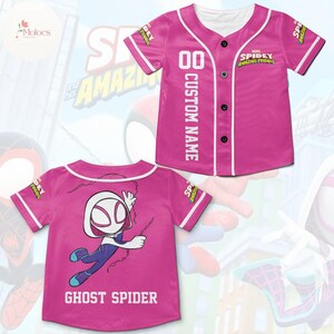 May include: Pink baseball jersey with white trim and buttons. The front of the jersey has the text "SPIDEY AMAZING FRIENDS" and "CUSTOM NAME". The back of the jersey has a cartoon image of Ghost Spider and the text "GHOST SPIDER".