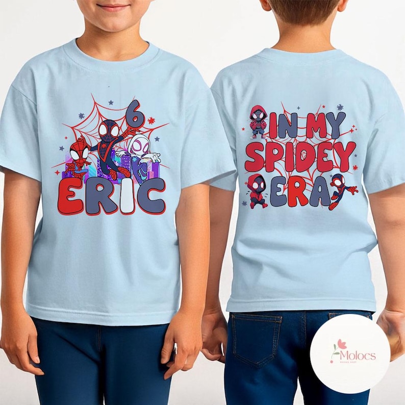 May include: Two light blue t-shirts with a Spiderman theme. The front shirt has a graphic of Spiderman characters and the text "6 ERIC". The back shirt has a graphic of Spiderman characters and the text "IN MY SPIDEY ERA".