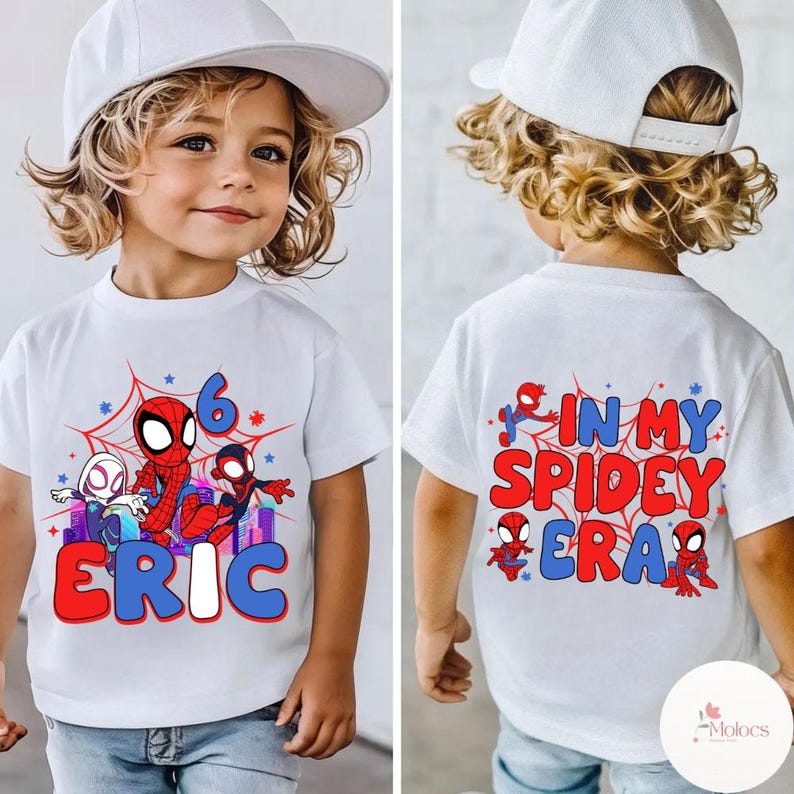 May include: White t-shirt with a red, blue, and black Spider-Man design. The shirt says "In My Spidey Era" on the back and "Eric" on the front with the number "6" and a spider web design.